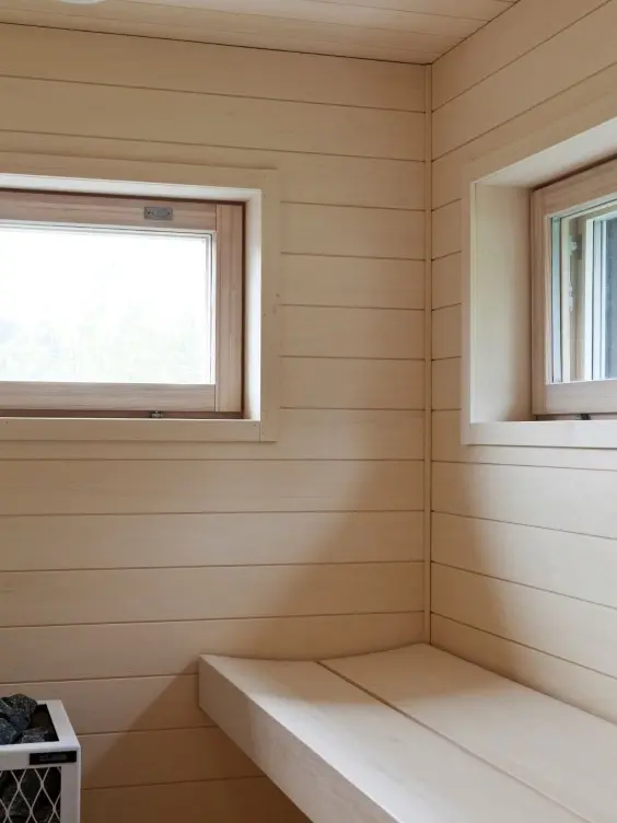 Vaalea moderni sauna leveillä laudepuilla 